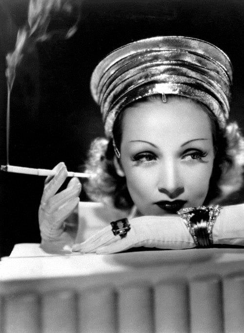 Marlène Dietrich tenant un porte cigarette blanc