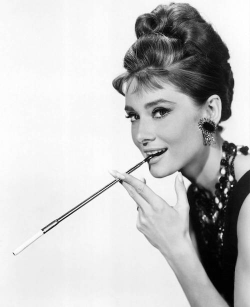 Audrey Hepburn tenant dans sa main un porte cigarette xxl dans le film Breakfast at Tiffany's